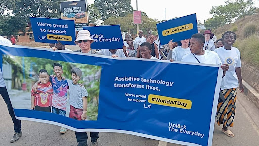 A group of people holding assistive technology transforms lives banner for world AT day