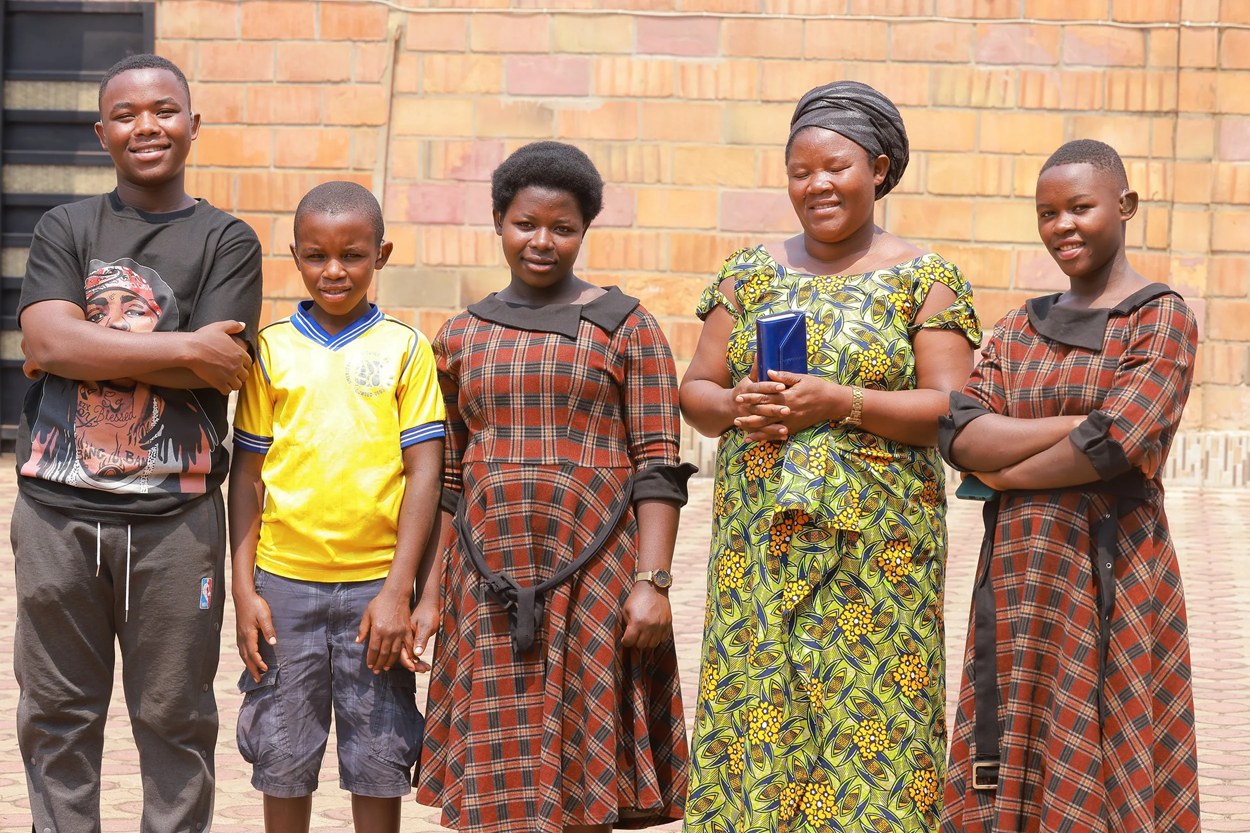 Mrs Jeannette, with her four children, who received digital hearing aids in February 2024.