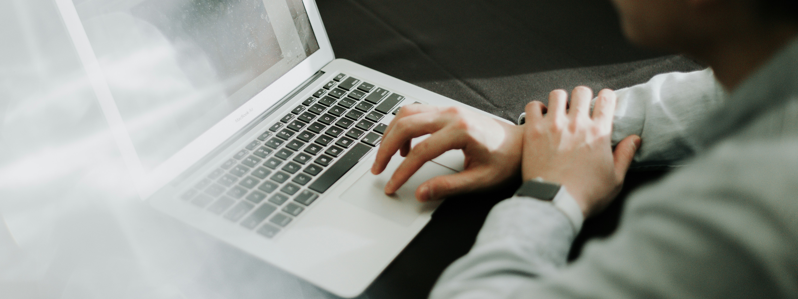 People working at a table using laptop computers.